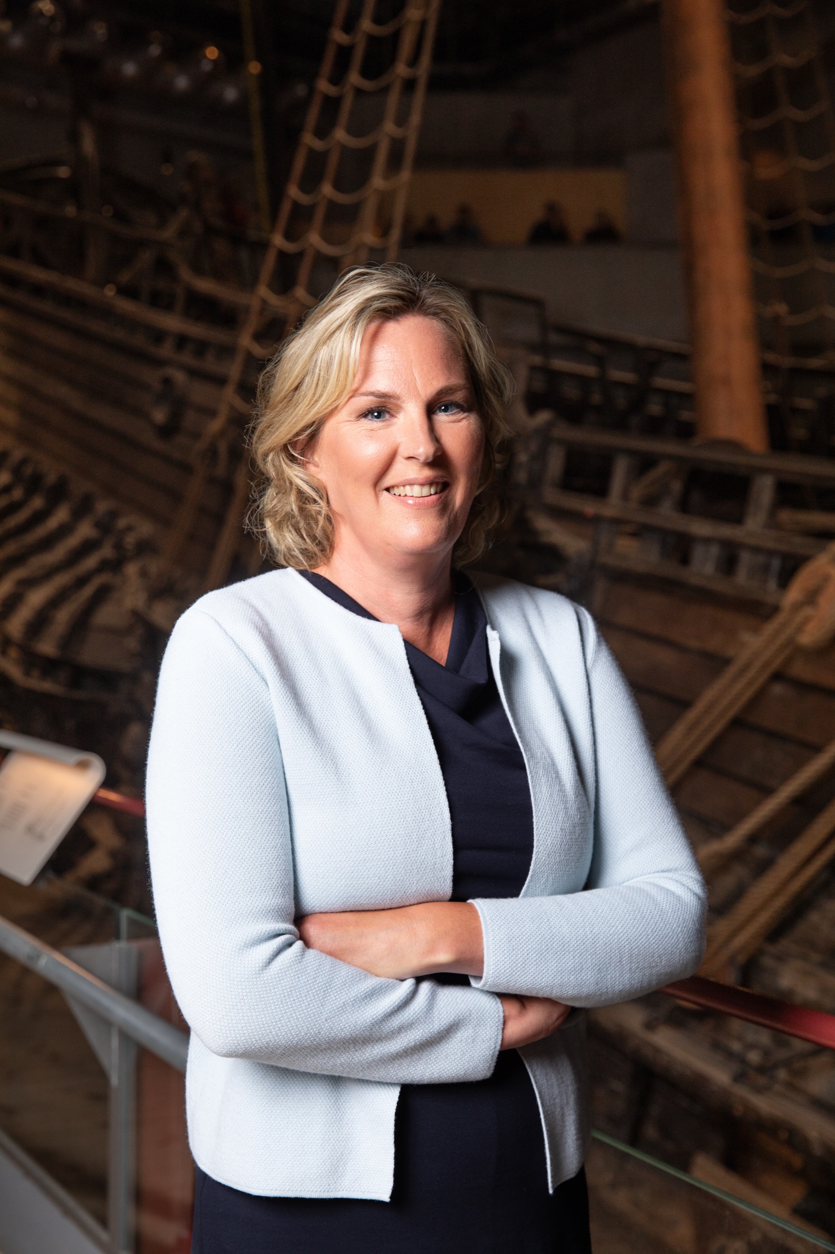 Photo of smiling blond woman in front of ship Vasa.